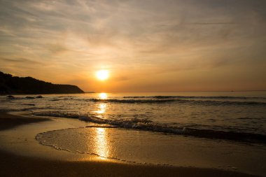 Denizde güzel bir gün batımı. Gün batımında plaj ve sörf.