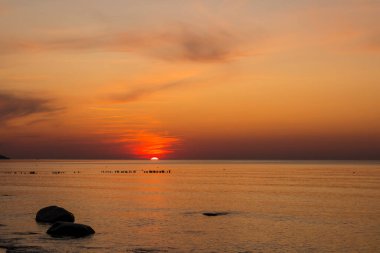 Denizde güzel bir gün batımı. Gün batımında plaj ve sörf.