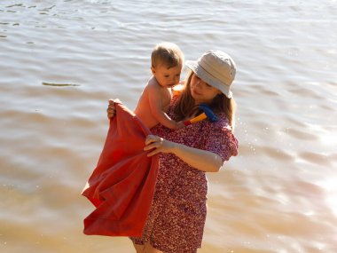 Annem gölde yüzdükten sonra bebeği havluyla örtüyor.