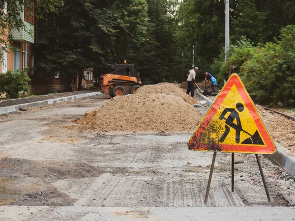 İnşaat halindeki bir yolun arka planında yol çalışması tabelası