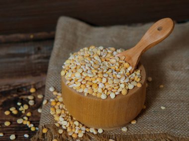 Tahta bir kasedeki kuru bezelyeler eski ahşap bir masada fotokopi alanı olan yakın plan.