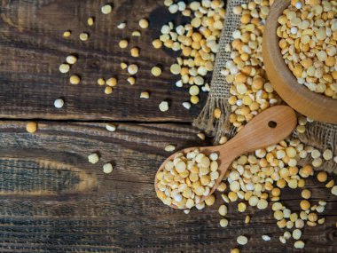 Tahta bir kasedeki kuru bezelyeler eski ahşap bir masada fotokopi alanı olan yakın plan.