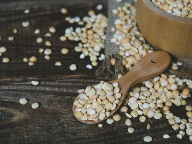 Tahta bir kasedeki kuru bezelyeler eski ahşap bir masada fotokopi alanı olan yakın plan.