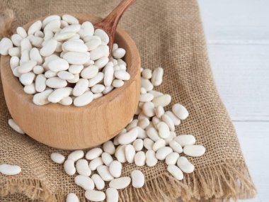 Tahta bir kaşıkta beyaz fasulye, tahta bir masada, kopyalama alanı.