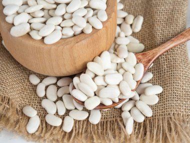 Tahta bir kaşıkta beyaz fasulye, tahta bir masada, kopyalama alanı.