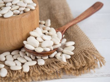 Tahta bir kaşıkta beyaz fasulye, tahta bir masada, kopyalama alanı.