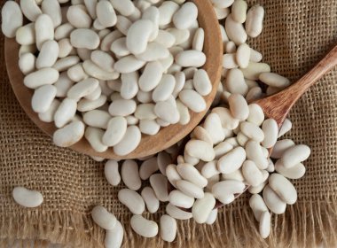 Tahta bir kaşıkta beyaz fasulye, tahta bir masada, kopyalama alanı.