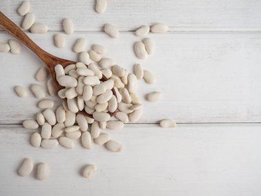 Tahta bir kaşıkta beyaz fasulye, tahta bir masada, kopyalama alanı.