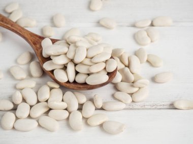 Tahta bir kaşıkta beyaz fasulye, tahta bir masada, kopyalama alanı.