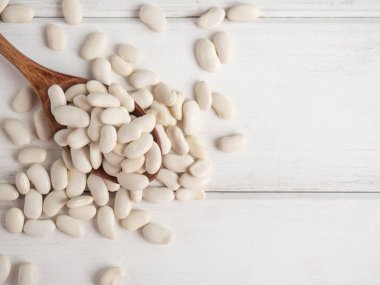Tahta bir kaşıkta beyaz fasulye, tahta bir masada, kopyalama alanı.