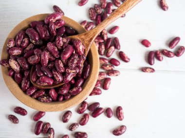 Beyaz ahşap bir masada, tahta bir kaşığa yakın plan kırmızı fasulye, kopyalama alanı