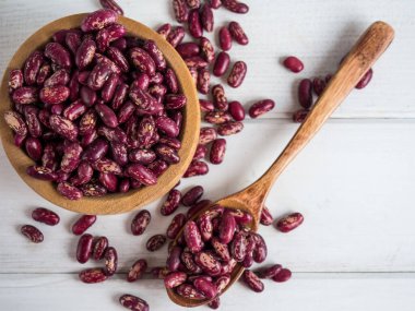 Beyaz ahşap bir masada, tahta bir kaşığa yakın plan kırmızı fasulye, kopyalama alanı