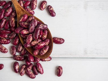 Beyaz ahşap bir masada, tahta bir kaşığa yakın plan kırmızı fasulye, kopyalama alanı