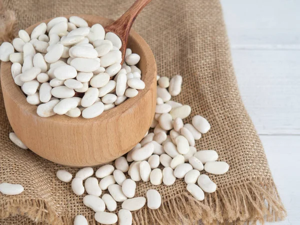 Tahta bir kaşıkta beyaz fasulye, tahta bir masada, kopyalama alanı.