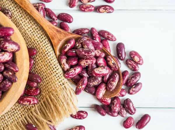 Beyaz ahşap bir masada, tahta bir kaşığa yakın plan kırmızı fasulye, kopyalama alanı