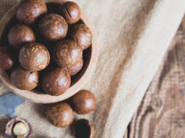 Tahta bir kasede eski ahşap bir masaya yakın plan fındık yığını.