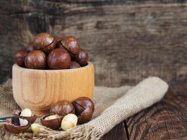 Tahta bir kasede eski ahşap bir masaya yakın plan fındık yığını.