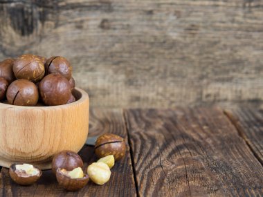 Tahta bir kasede eski ahşap bir masaya yakın plan fındık yığını.