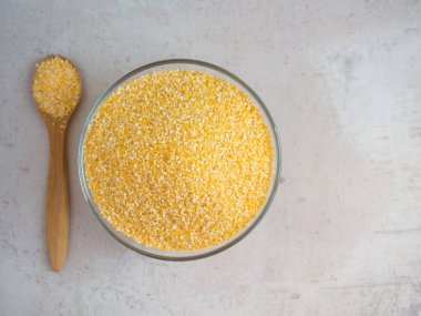 Mısır gevrekleri kasede ve tahtadan bir kaşıkta mısır taneleriyle.