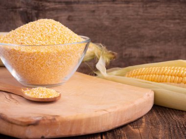 Cam bir kasede mısır ezmesi ve tahta kaşık eski bir tahta masaya yakın çekim, boşluğu kopyala