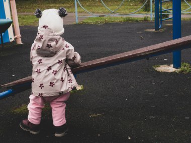 Bir sonbahar günü parkta oynayan sevimli ve komik bir bebek.