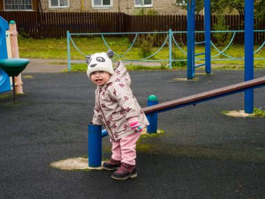 Bir sonbahar günü parkta oynayan sevimli ve komik bir bebek.
