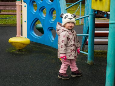 Bir sonbahar günü parkta oynayan sevimli ve komik bir bebek.