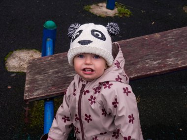 Bir sonbahar günü parkta oynayan sevimli ve komik bir bebek.