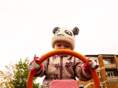 Bir sonbahar günü parkta oynayan sevimli ve komik bir bebek.