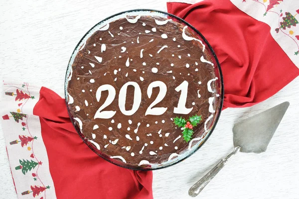 2021 chocolate new years cake and cake server on red christmas tablecloth