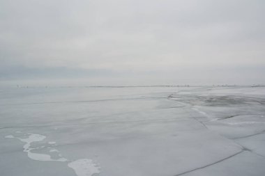 Donmuş göl üzerinde buz kırılan kış manzarası sisli bir sabah