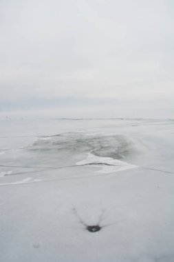 Donmuş göl üzerinde buz kırılan kış manzarası sisli bir sabah