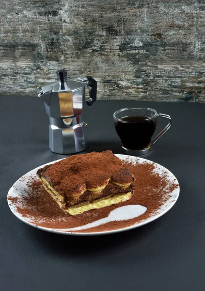 Tiramisu, Italian dessert, layered with mascarpone cheese and chocolate and espresso coffee maker and cup of espresso coffee