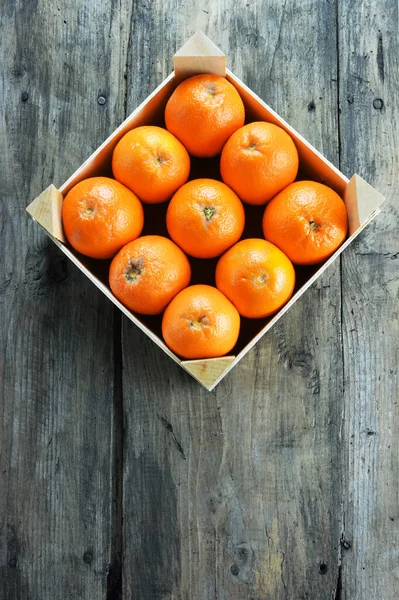 木の素朴なテーブルの上の木製のフルーツクレートのオレンジ — ストック写真