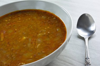 Lentil soup and silver spoon beside clipart