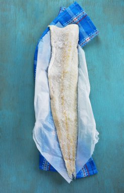 Turkuaz mutfak havlusunda tuzlu morina filetosu.