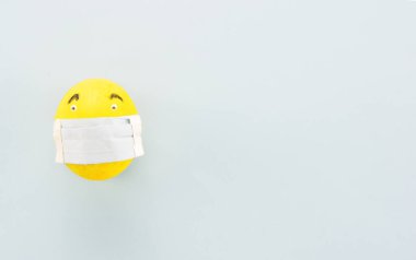 Açık mavi arkaplanda koruma maskeli yumurta