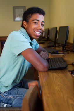 Teenager in a computer lab. clipart