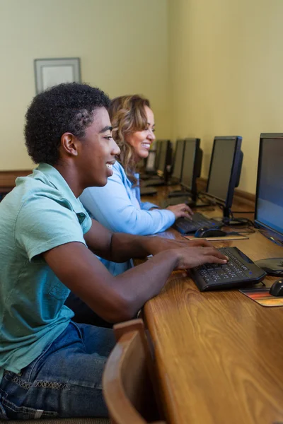 Estudiantes en la biblioteca trabajando en la computadora — Foto de Stock