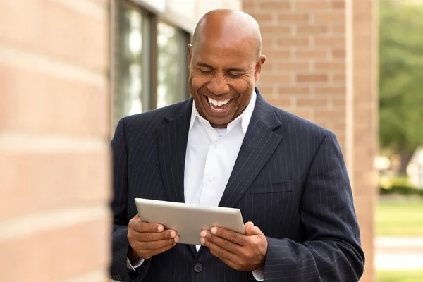 Afrikanischer amerikanischer Geschäftsmann vernetzt sich auf einem Tablet — Stockfoto