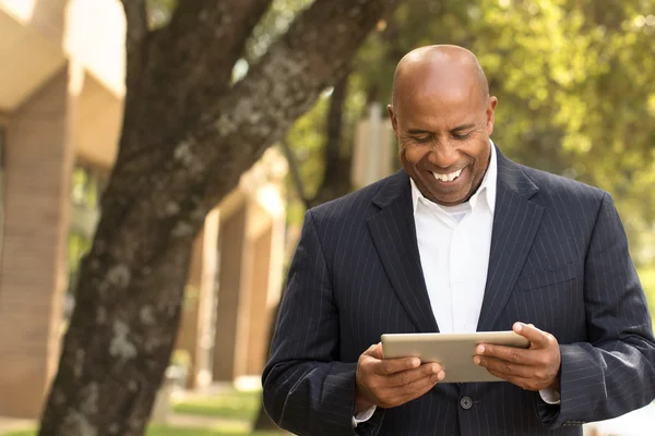 Afrikanischer amerikanischer Geschäftsmann vernetzt sich auf einem Tablet — Stockfoto