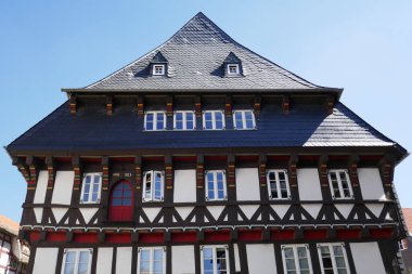 Almanya 'nın Goslar şehrinin merkezinde Rammelsberg yakınlarındaki kayrak çatılı, yarı ahşap bir ön cephe oluşturmanın bir parçası.