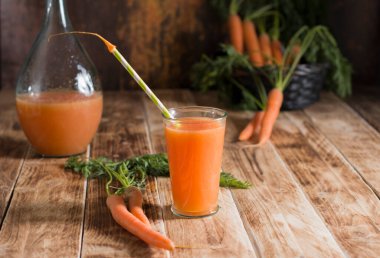 Taze sıkılmış havuç suyu, çiğ havuç, vejetaryen sebze vitamin içeceği, klasik natürmort yaşam konsepti, ahşap arka planda taze havuç suyu, sade hayat.