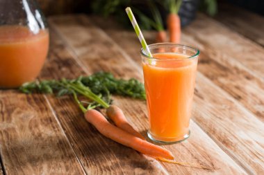 Taze sıkılmış havuç suyu, çiğ havuç, vejetaryen sebze vitamin içeceği, klasik natürmort yaşam konsepti, ahşap arka planda taze havuç suyu, sade hayat.