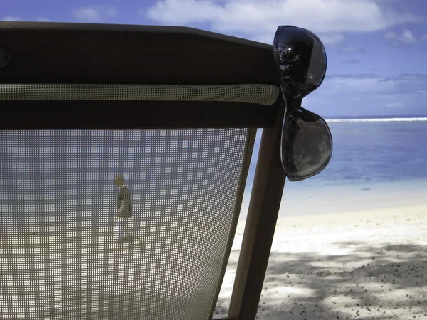 Deckchair, óculos de sol e andador em uma praia de areia Fotos De Bancos De Imagens Sem Royalties