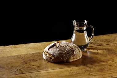Bir somun ekmek ve bir sürahi su ahşap tablo