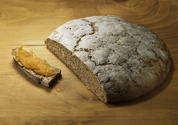 Cortar el pan de centeno recién horneado con mermelada de naranja —  Fotos de Stock