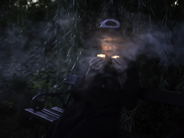 Scary dark witch with two candles — Stock Photo, Image