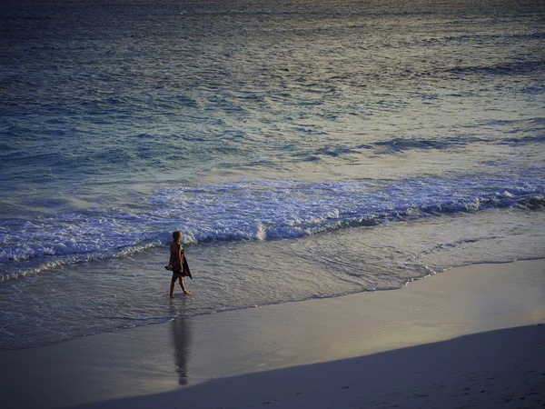 Kvinna på en sandstrand på en mulen dag — Stockfoto