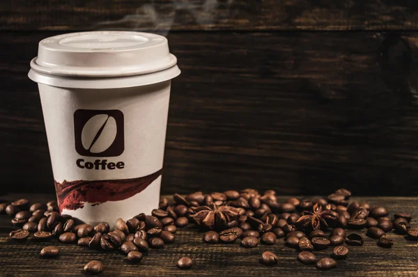 Чашка кофе и кофейных зерен на старом деревянном фоне — стоковое фото